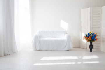 home decor white room with sofa and flowers in a vase