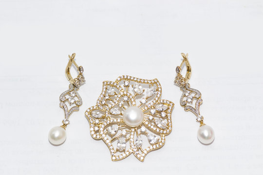 gold earrings and brooch with pearls