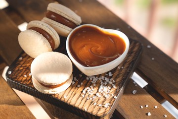 Caramel Macaroons with salted caramel on wooden background