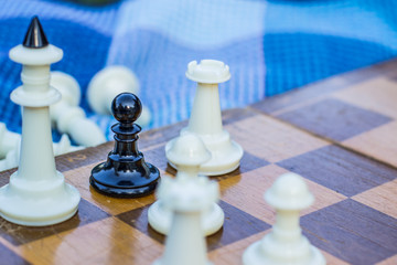 chess game situation black pawn around white figures on wooden desk surface background 
