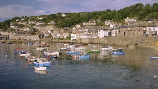 Elevated pan across the pretty harbour of Mousehole in Cornwall 