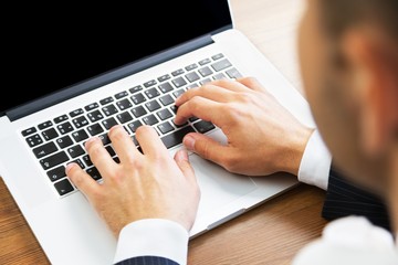 Closeup of a Businessman Typing on a Laptop