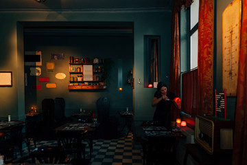 waitress engaged in lighting up a candle during the preparation of the dining room in a romantic restaurant
