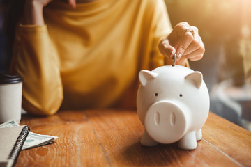 hand put money coin into piggy for saving money wealth - Powered by Adobe