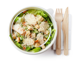 Caesar salad in take away bowl on white background; from above