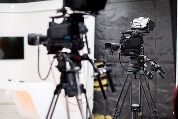 Camera in studio broadcasting news.