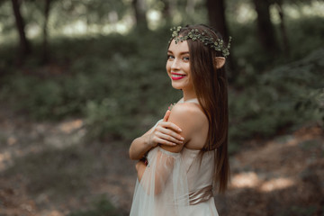 smiling girl with elf ears and with floral wreath on head © LIGHTFIELD STUDIOS