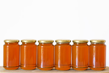 Jars of organic honey on white background