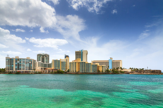 Beautiful view on the beach hotels in San Juan, Puerto Rico, with a blue sky and green ocean
