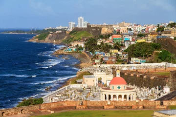 Fototapeten Coastline San Juan looking towards fort San Cristobal and the Santa Maria cemetery from Del Morro, on a summer day © dennisvdwater
