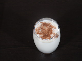 Traditional winter eggnog with milk, rum and cinnamon, sprinkle with grated nutmeg, selective focus,Glass mugs filled with homemade egg nog with cinnamon sticks, Cinnamon Milk, Dalchini Milk