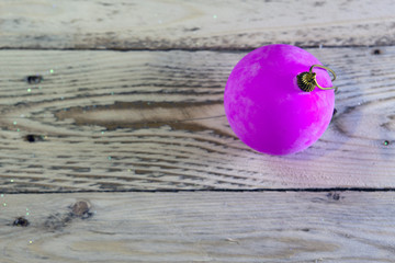 pink christmas ball on wooden boards