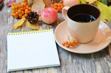 Workspace with golden leaves, notebook, coffee cup. Stylish office desk. Autumn or Winter concept. Flat lay, top view.