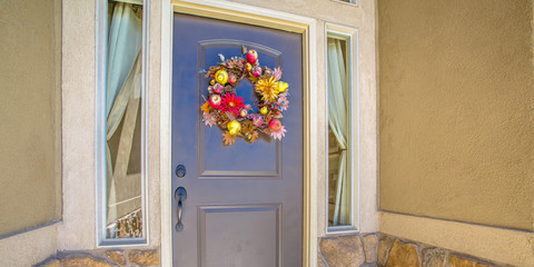 Blue front door with flower wreath between windows