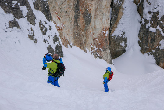 Off-piste skiers are practicing rock climbing.