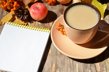 Workspace with golden leaves, notebook, coffee cup. Stylish office desk. Autumn or Winter concept. Flat lay, top view.