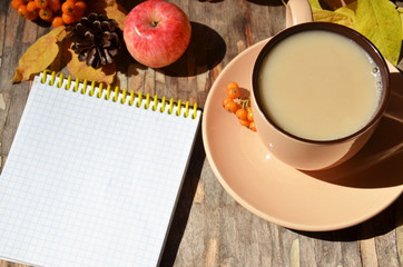 Workspace with golden leaves, notebook, coffee cup. Stylish office desk. Autumn or Winter concept. Flat lay, top view.