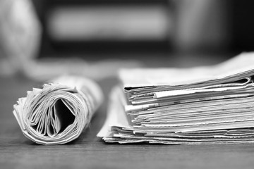 Stack of newspapers and rolled paper. Folded pages of journals with news and roll of tabloid...