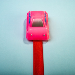 toy car and a red ribbon on a green background. Web banner.