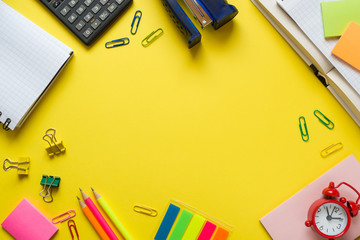 Office supplies on yellow table with copy space. Education concept, school and office.