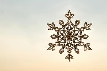 Sparkling huge snowflake on a sunset sky background. Winter and Christmas concept. 