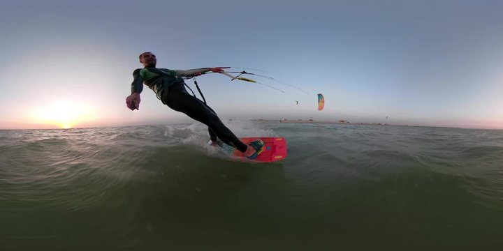 A man in a suit for diving deals with kitesurfing at dawn, 360 degrees