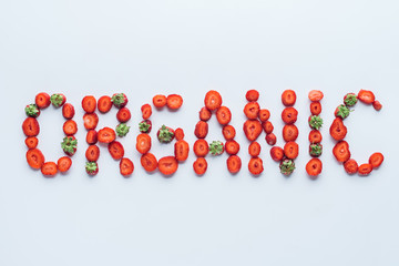 top view of organic inscription made of sliced strawberries on white surface