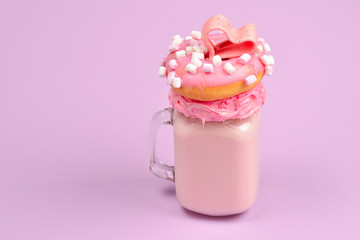 Pink strawberry freakshake with marshmallow and sweets.