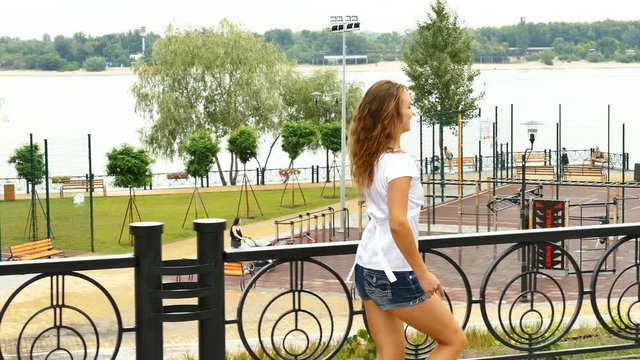 
    4K. Young  slender girl  go with dance on city street park. Steady shot, Bright happy  emotions
