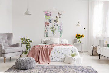 Nature lover's bright bedroom interior with a wall art of flowers and birds painted on a fabric...