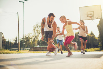 Happy family playing basketball together.