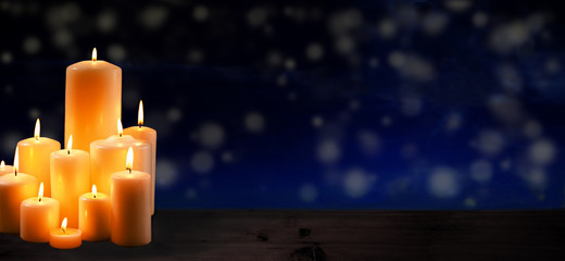 group of burning candles to commemorate ober dark blue background
