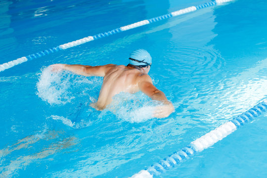 Image from back of sports man swimming in pool