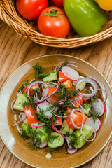 Fresh salad with tomatoes, onion and cucumbers.