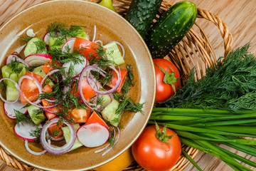 Fresh salad with tomatoes, onion and cucumbers.