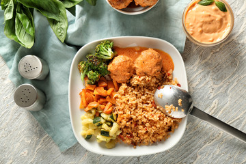 Tasty boiled rice with meatballs and vegetables on plate