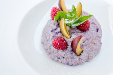 Oatmeal porridge with blueberries, raspberries and peach.