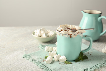 Cup of delicious cocoa with marshmallows on light table