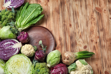 Different types of cabbage on wooden background