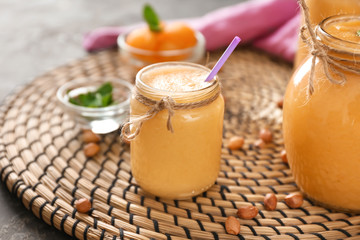 Glass jars of tasty melon smoothie on table