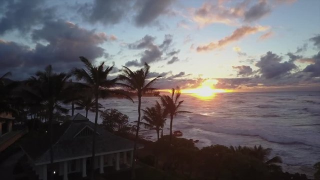Aerial view of sunset over ocean in tropical paradise. big waves, palms