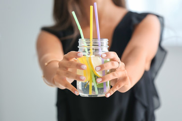 Young woman with mason jar of fresh lemonade, closeup