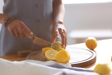 Young woman preparing fresh lemonade at home