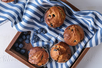 Tray with tasty blueberry muffins on white table