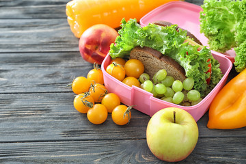 Lunch box with appetizing food on wooden table