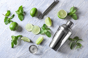 Cocktail shaker and ingredients for mojito on table