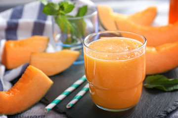 Glass of tasty melon smoothie on table