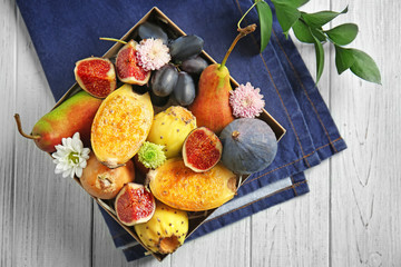 Various fresh fruits in box on wooden table