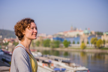 A tourist woman is walking around Prague on a sunny day. 
