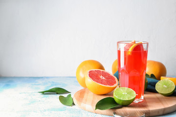 Glass of refreshing grapefruit lemonade on wooden board